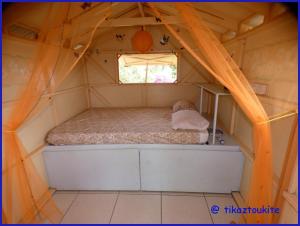 a bed in the inside of a tent with a window at Tikaz Toukité in Méro