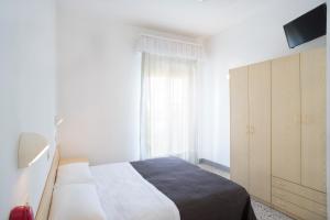 a white bedroom with a bed and a window at K2 Hotel in Cattolica
