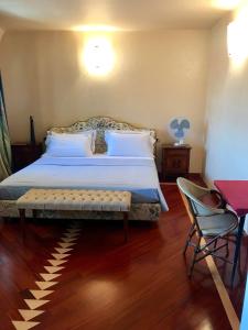 a bedroom with a large bed and a chair at B&B Independente in Assago
