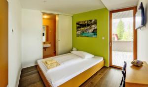 a bedroom with a bed and a desk and a window at Hotel Sanje ob Soči ***/**** in Bovec