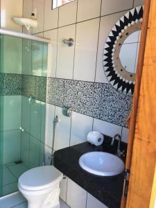 um banheiro com um vaso sanitário, uma pia e um espelho em Casa Esmeralda para descanso em Pirenópolis