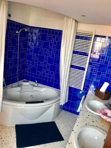 ein blau gefliestes Bad mit einer Badewanne und einem Waschbecken in der Unterkunft B&B Independente in Assago