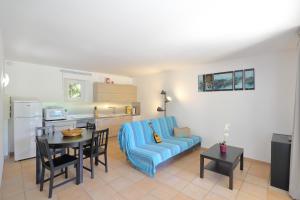 a living room with a blue couch and a table at Au bastidon de Gordes in Gordes