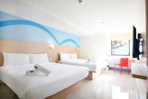 Hop Inn Hotel Alabang Manila في مانيلا: غرفة فندقية بسريرين ومكتب