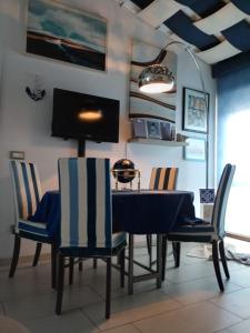 - une salle à manger avec une table, des chaises et une télévision dans l'établissement Mariolina Casa Vacanze, à Capoterra