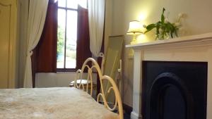 a bedroom with a bed with a fireplace and a window at Kinneil Self Catering in Lamlash