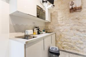 a kitchen with a sink and a counter top at CMG - Montorgueil - Residence Saint Sauveur in Paris