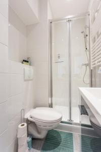 a white bathroom with a toilet and a shower at CMG - Montorgueil - Residence Saint Sauveur in Paris