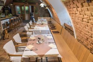 a long table in a restaurant with white tables and chairs at Hotel Koníček in Uherské Hradiště