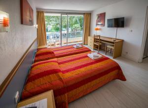 ein Hotelzimmer mit einem Bett, einem Schreibtisch und einem Fenster in der Unterkunft Hôtel Le Domaine du Mas Blanc by Popinns in Alénya