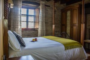 een slaapkamer met een bed met een pop erop bij Alén do Mis - Hotel Rural in Foz