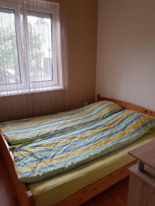 ボニャルツバシュにあるLívia Apartmanokのベッドルームにカラフルな毛布が付いたベッド1台