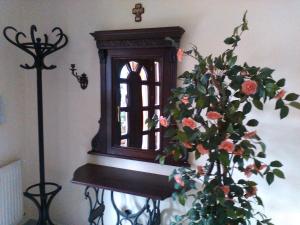 una ventana y un jarrón con flores en una mesa en Zöld Sziget Vendégház, en Eger