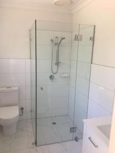 a bathroom with a glass shower with a toilet at Gorgeous Subiaco cottage in Perth