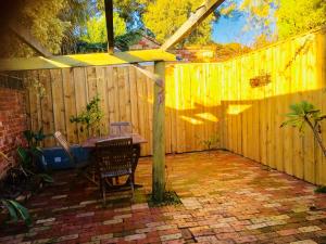 a patio with a table and a wooden fence at Gorgeous Subiaco cottage in Perth