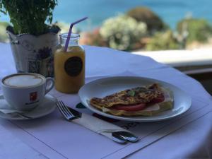 un plato con un sándwich en una mesa con una taza de café en Cavo D' Oro, en Pireo