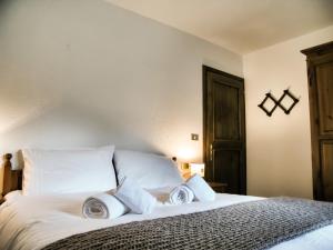 una camera da letto con un letto bianco con cuscini bianchi di Apartment "La maison des Guides" a Courmayeur