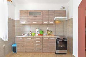 kuchnia z drewnianymi szafkami i kuchenką w obiekcie Apartments Gracijano 1724 w mieście Ližnjan