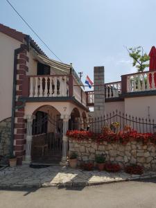una casa con una valla y flores delante de ella en Apartments Liljana Privlaka, en Privlaka