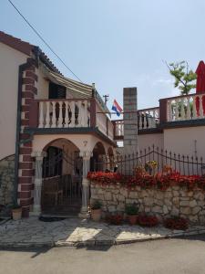 dom z płotem i kwiatami przed nim w obiekcie Apartments Liljana Privlaka w mieście Privlaka