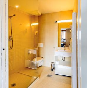 
a bathroom with a toilet, sink, and shower stall at Hotel Sanje ob Soči ***/**** in Bovec

