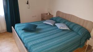 a large bed with blue sheets and pillows on it at Sotto il Castello in Corigliano Calabro