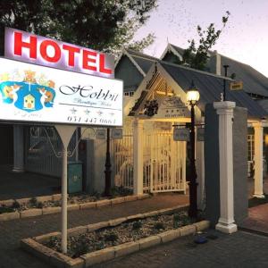 un hotel con un cartel frente a un edificio en Hobbit Boutique Hotel en Bloemfontein