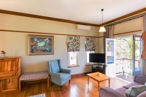 a living room with a couch and a tv at Eendracht Hotel in Stellenbosch