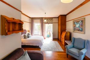 een slaapkamer met een bed, een bank en een stoel bij Eendracht Hotel in Stellenbosch