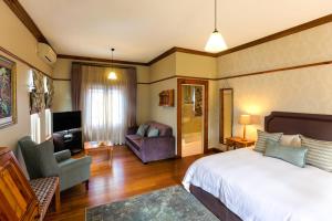 ein Schlafzimmer mit einem Bett und ein Wohnzimmer in der Unterkunft Eendracht Hotel in Stellenbosch