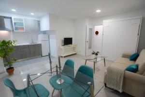 uma sala de estar com um sofá, uma mesa e cadeiras em Apartamento En Los Patios De San Basilio em Córdoba