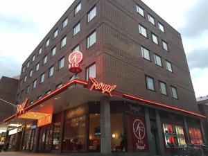 una tienda frente a un edificio de ladrillo con letreros de neón. en Apartments Centralstation, en Uppsala