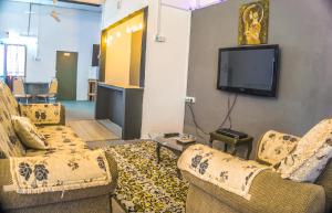 a living room with two couches and a flat screen tv at Ipoh Boutique Stay in Ipoh