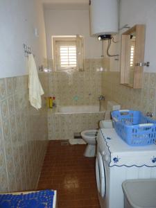 a bathroom with a tub and a toilet and a sink at Apartman MajaS in Makarska