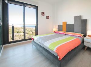 a bedroom with a large bed and large windows at Alex Sun in La Mata