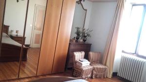 - une chambre avec un miroir, une chaise et un lit dans l'établissement B&B Al Mutpron, à Casale Corte Cerro