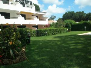 a yard in front of a house with green grass at A Apartmento Solar dos Pinheiros in Vilamoura