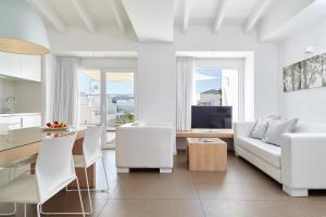 Una sala de estar blanca con un sofá blanco y una mesa. en Ibiza Sun Apartments, en Playa d'en Bossa