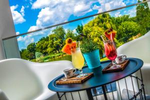 a table with two drinks on a balcony with a view at Open Hotel Szentes in Szentes