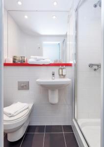 a bathroom with a toilet, sink, and bathtub at Haymarket Hub Hotel in Edinburgh