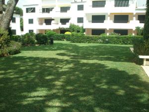 a green yard with a bench in front of a building at Semi-Detached Villa in Vilamoura