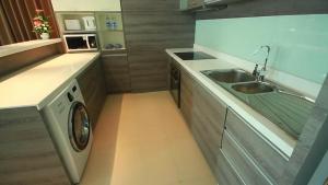 a kitchen with a sink and a washing machine at The Vertical Suite in Bangkok