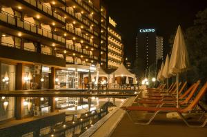 ein Hotel mit Stühlen und einem Pool bei Nacht in der Unterkunft Gladiola 3-star in Goldstrand