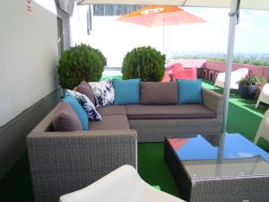 a patio with a couch and an umbrella at Palace Hostel Vienna in Vienna