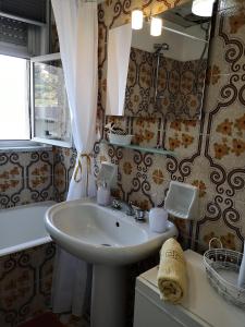 bagno con lavandino e specchio di Taormina Rising Sun Apt a Forza dʼAgro