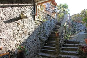 un escalier en pierre menant à un mur en pierre dans l'établissement Palazzo Vertemate Traona, à Traona