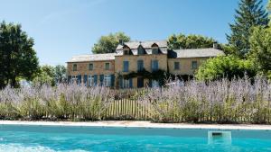 een oud huis met een zwembad ervoor bij Le Couvent de Neuviale in Parisot
