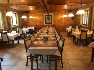 a long table in a restaurant with white tables and chairs at Gasthof zum Gamsjäger in Sankt Nikolai im Sölktal