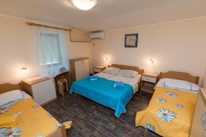 a small room with two beds and two tables at Sobe in apartma Pilih in Vipava