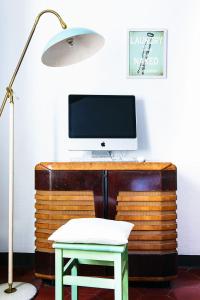 a desk with a computer monitor and a chair and a lamp at Little Garden House in Cernobbio